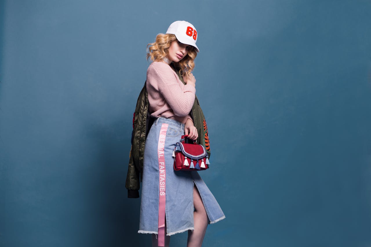 about-03 Trendy fashion model poses in a stylish studio setting, showcasing a chic outfit with accessories.