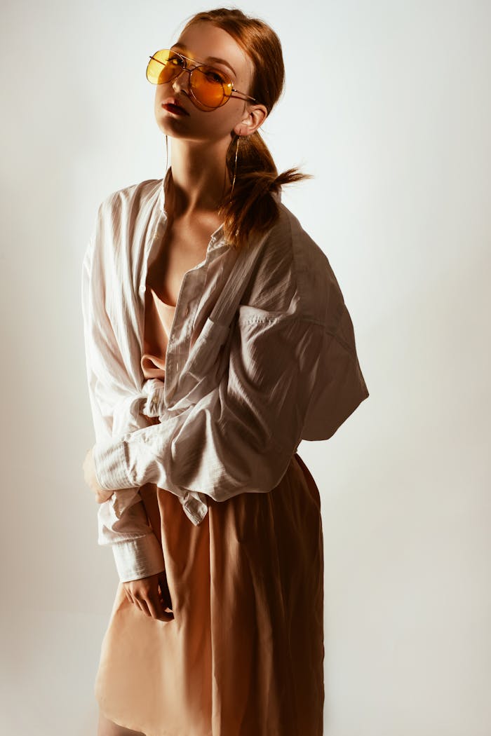 menu-01 Trendy woman posing in oversized shirt and sunglasses, exuding modern fashion style.
